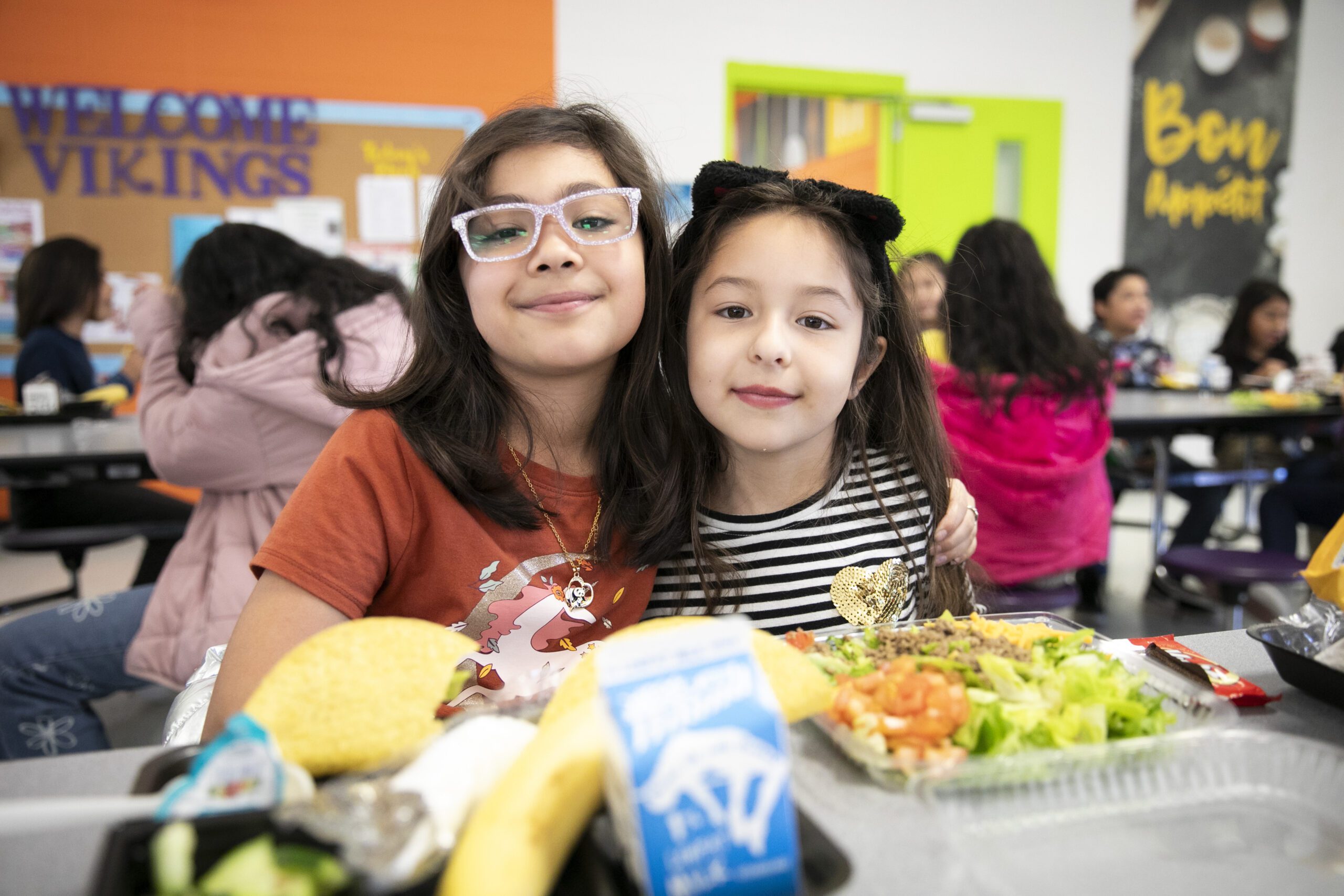 two girls at a table in school cafeteria